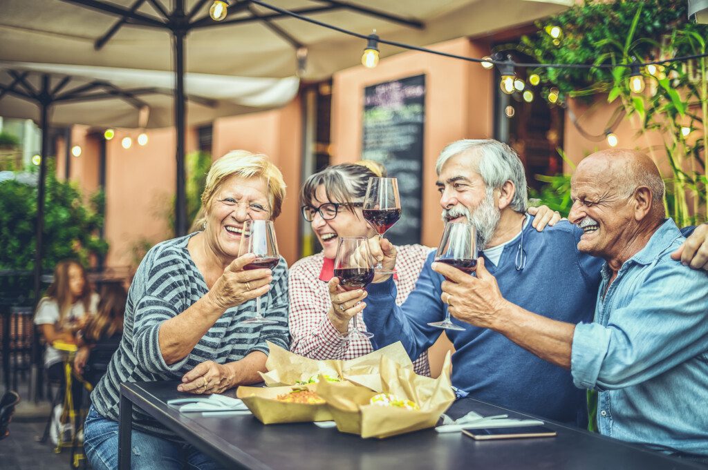 seniors enjoying a glass of wine together outdoors